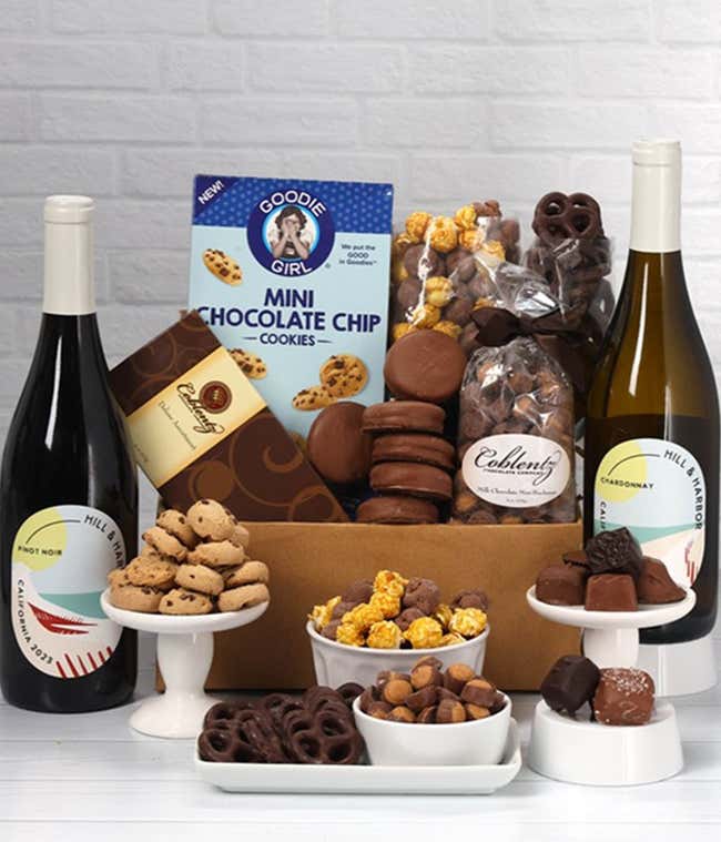 A gift set with 2 bottles of wine - red and white, paired with chocolate pretzels, caramel popcorn, mini cookies, chocolate peanut butter buckeyes, six chocolate-covered Oreos, and a box assorted chocolates.