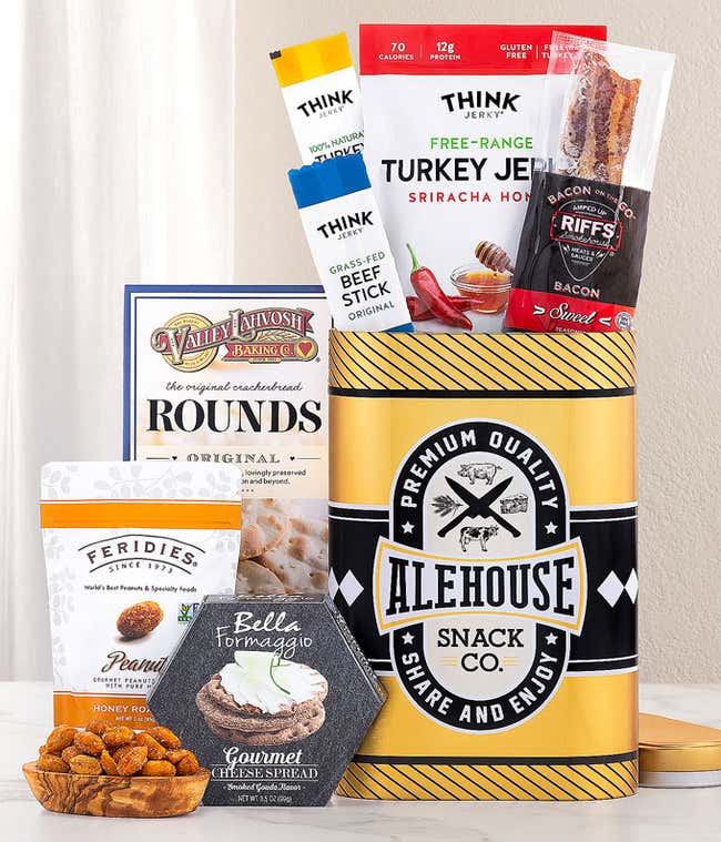 This Alehouse-themed gift tin features a sleek black and yellow design filled with gourmet snacks. It includes Think Jerky's Turkey Jerky and Beef Sticks, Riffs Bacon, Valley Lahvosh crackers, Feridies Peanuts, and Bella Formaggio Cheese Spread. ?&amp;#