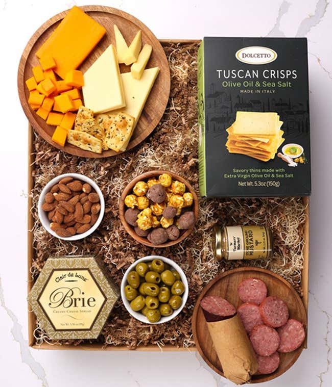 A gourmet charcuterie gift set featuring Tuscan crisps, focaccia crackers, smoked cheddar, garlic &amp; onion cheese, brie spread, olives, mustard, almonds, chocolate-covered popcorn, and summer sausage.  Perfect for entertaining.