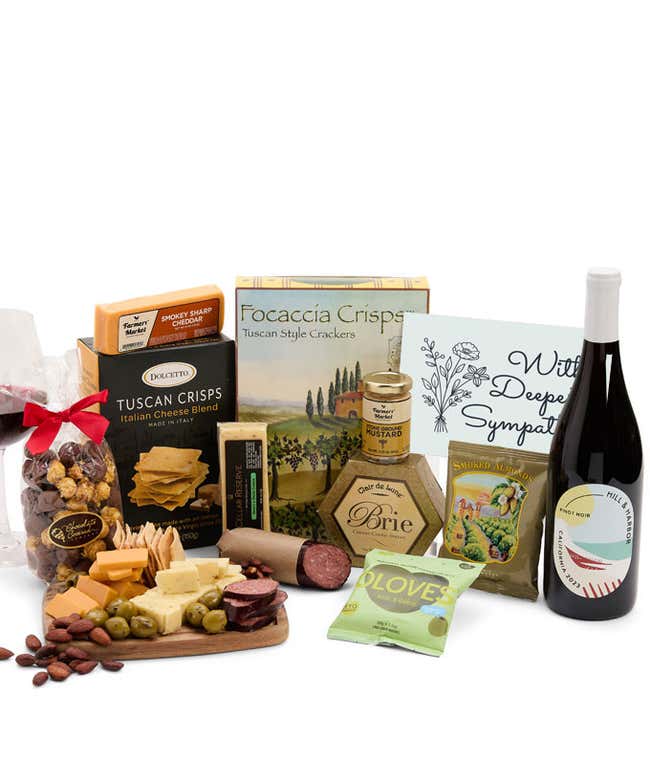An abundent charcuterie gift set with Tuscan crisps, focaccia crackers, 3 cheeses, olives, mustard, summer sausag, almonds, chocolate-covered popcorn, a bottle of Pinot Noir, and a sympathy card. 