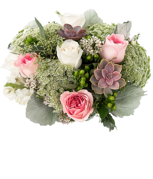 Partial image of A floral arrangement featuring white roses, pink roses, succulents, white stock, hypericum berries, Queen Anne's lace, white waxflower, and seeded eucalyptus, with an optional glass vase. without vase.