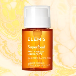 Elemis, Ustawi, and Ole Henriksen skin-care products on a yellow and peach marble background
